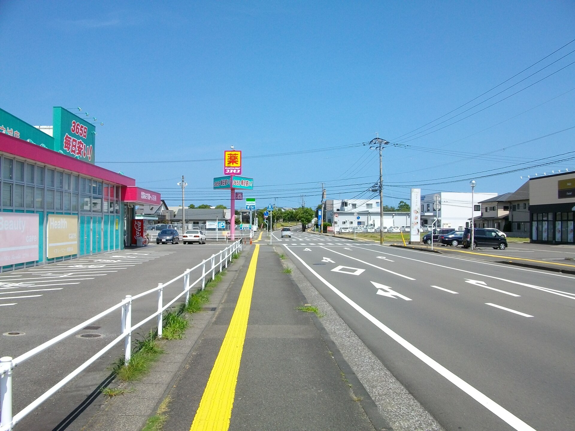 吉村町天神前付近の道路。ロードサイド店が並ぶ