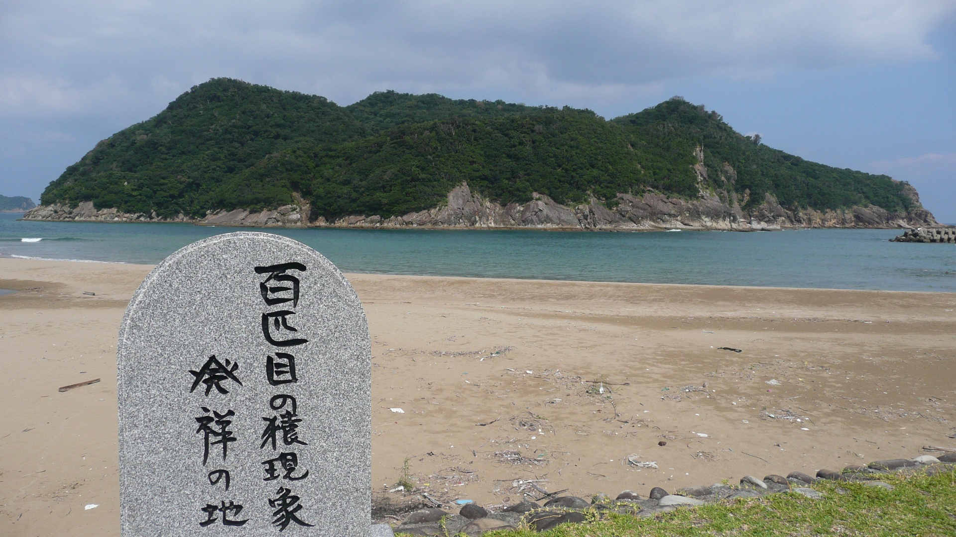 石波海岸に立つ「百匹目の猿現象発祥の地」の石碑と幸島