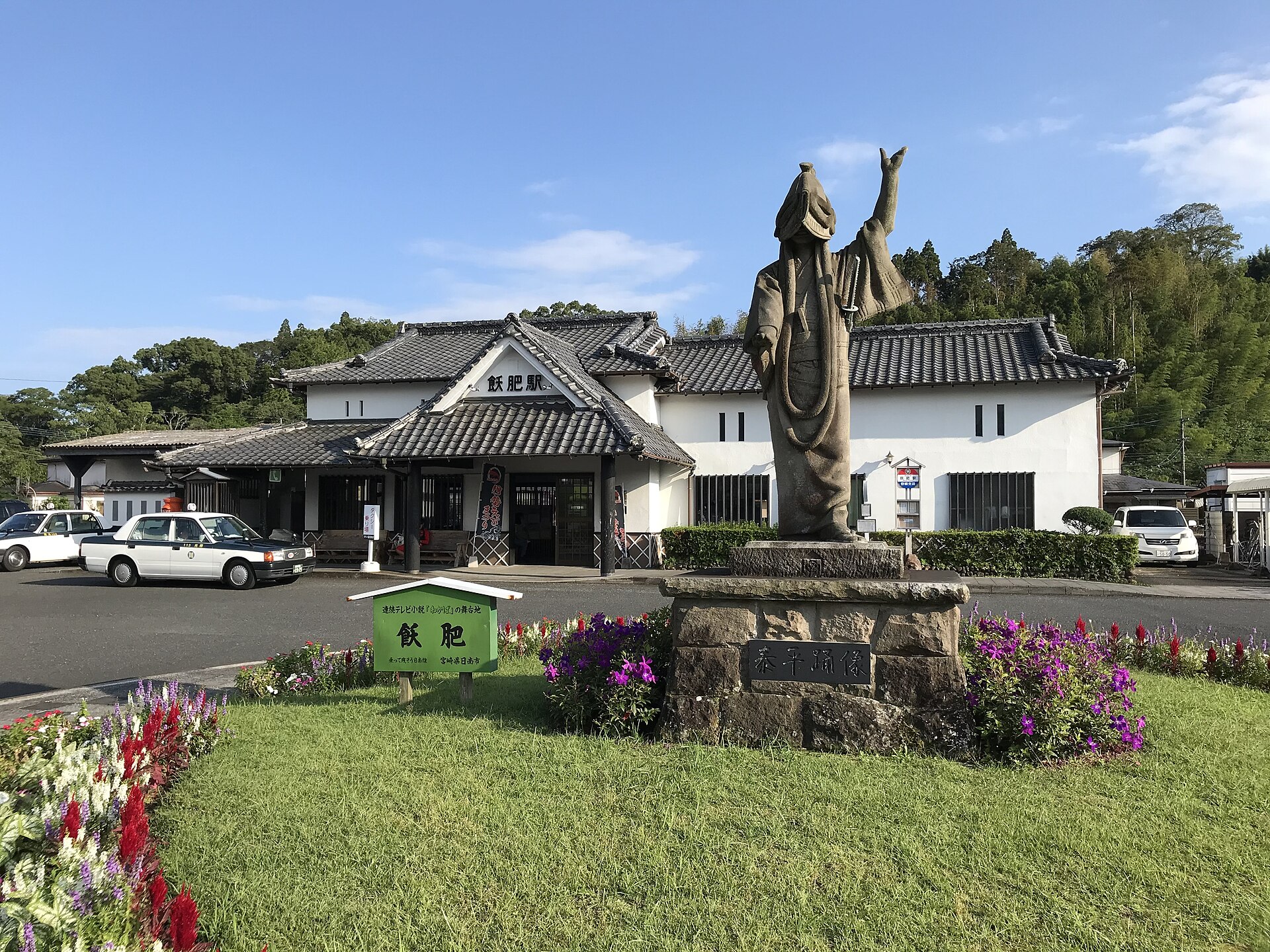 飫肥駅の駅舎と泰平踊の像